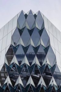 شیشه اسپندرال (Spandrel Glass) نوعی شیشه مات یا غیر شفاف است که برای پوشاندن بخش های مختلف نمای ساختمان و پنهان کردن اجزایی مانند تیرها، لبه سقف و تاسیسات استفاده می شود. این شیشه معمولا با رنگ سرامیکی یا پوشش مخصوص تولید می شود تا نمایی یکدست ایجاد کند.